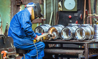 Downing employee working on grinding parts for new wellhead equipment